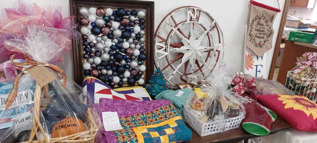 A table with crafts (quilts, mirrors, baskets, etc.)